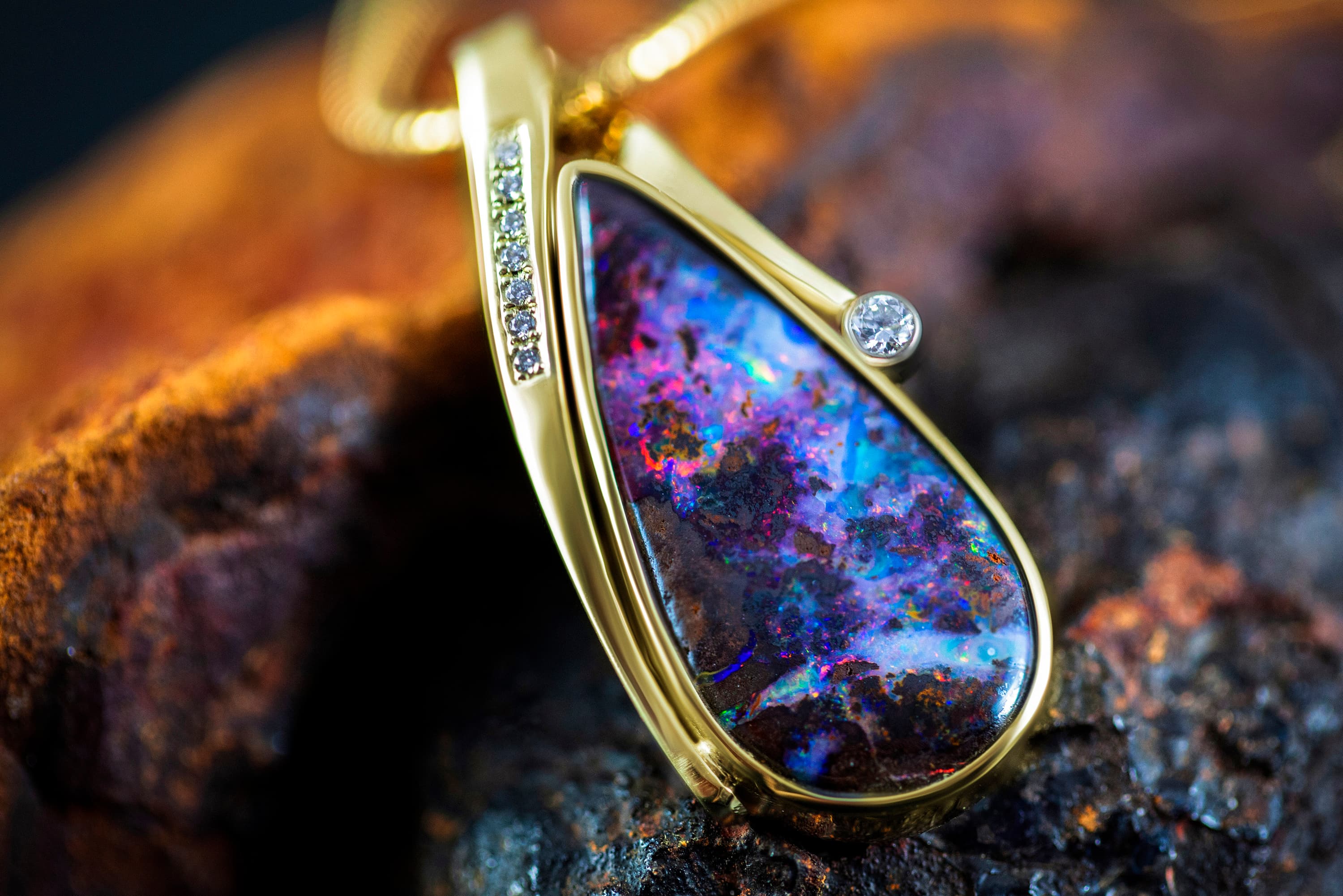 Anhänger mit Opal in goldener Fassung auf Rohgestein